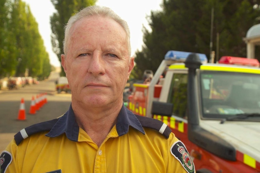 Greg Mullins stands next to a firefighting vehicle.