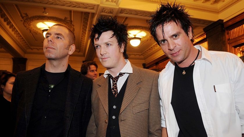 Members of the band The Living End pose for photographs on the red carpet