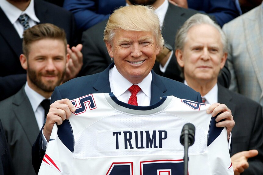 U.S. President Donald Trump holds up a New England Patriots jersey
