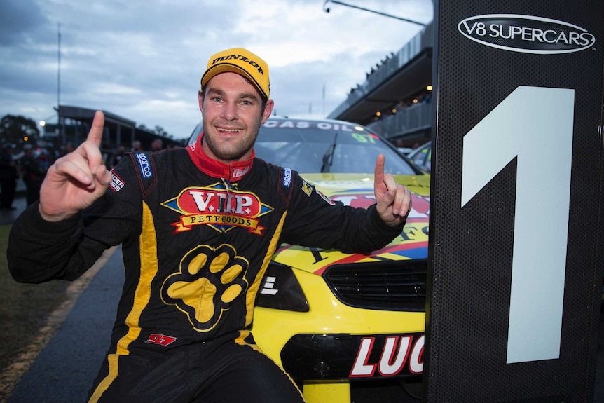 A racing car driver celebrates a win