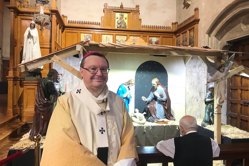 A bishop in front of a nativity scene