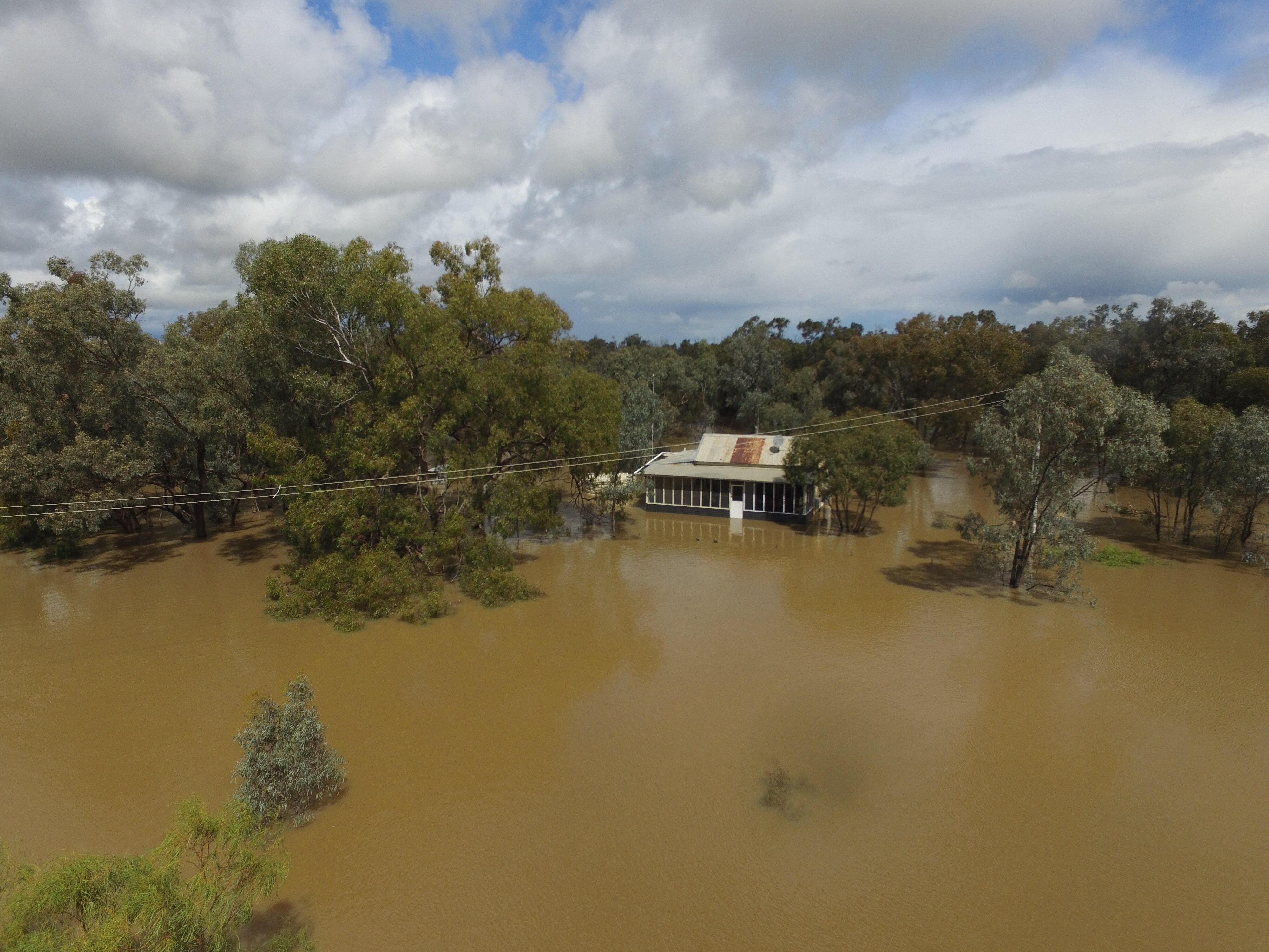 A drone image of a homestead surrounded by deep floodwater