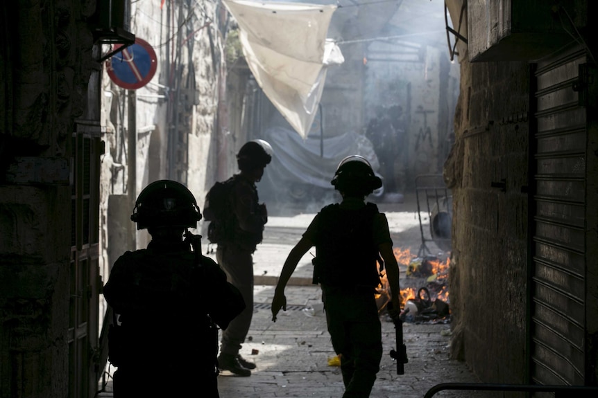 Israeli border police officers run during clashes with Palestinians