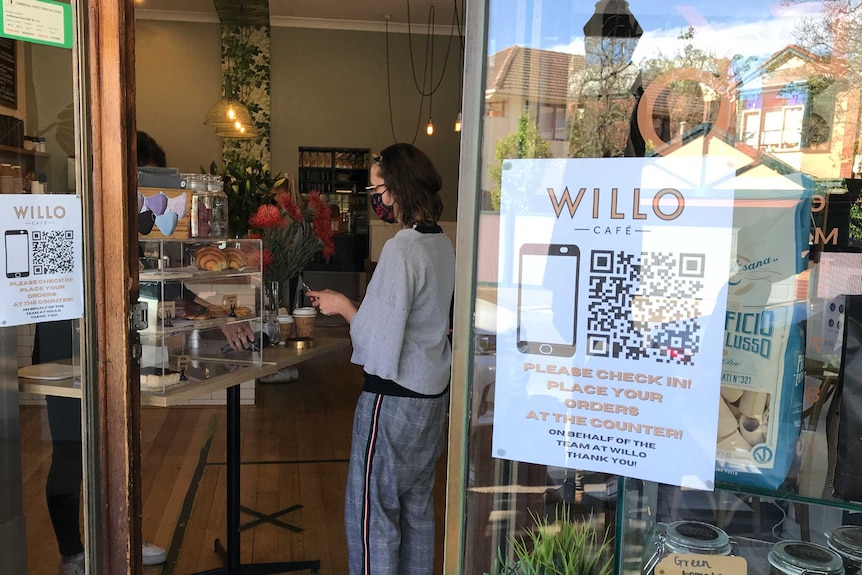 A QR code in the window of a Melbourne cafe telling customers to check in.