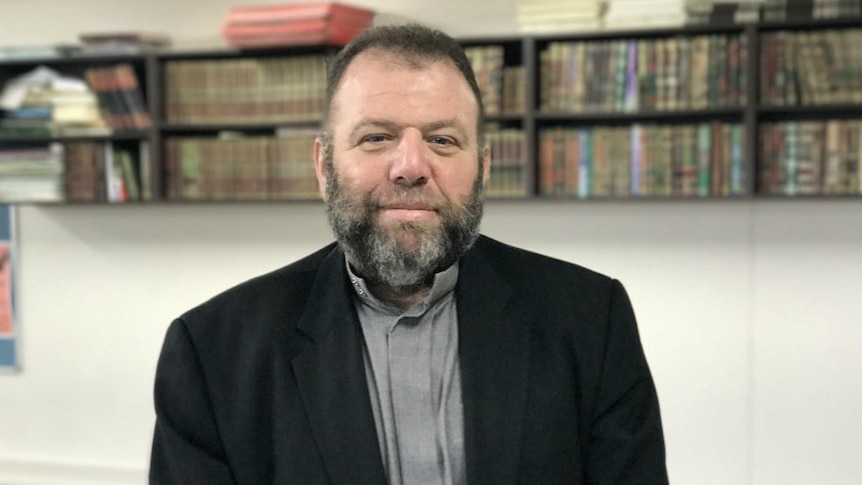 Bearded man sits alone in an office