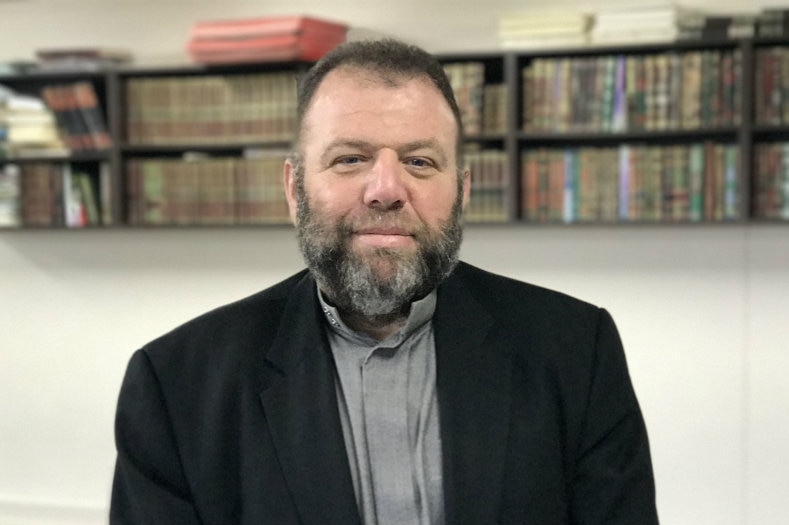 Bearded man sits alone in an office