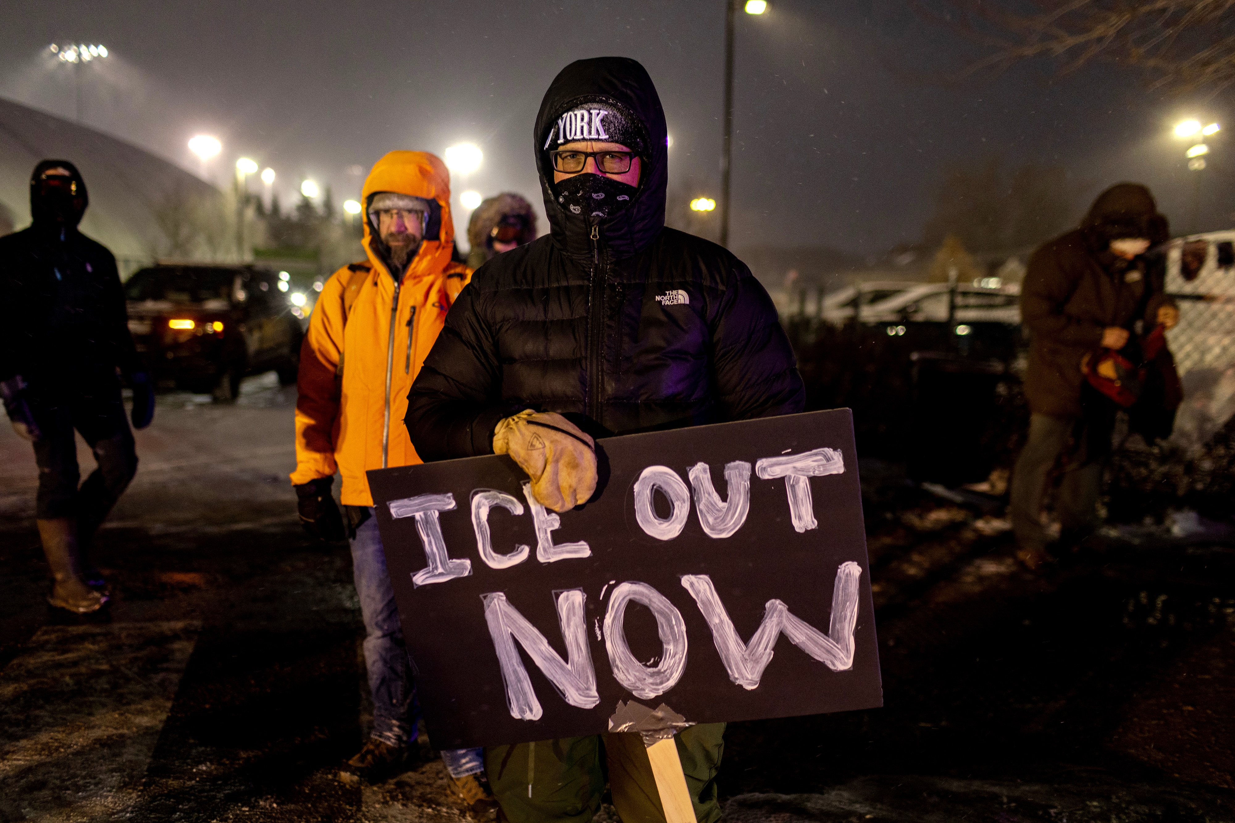 A man hold a sign demanding ICE agents leave Minnesota.