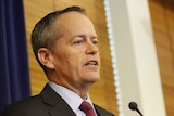Opposition leader Bill Shorten talks into a microphone during a press conference.