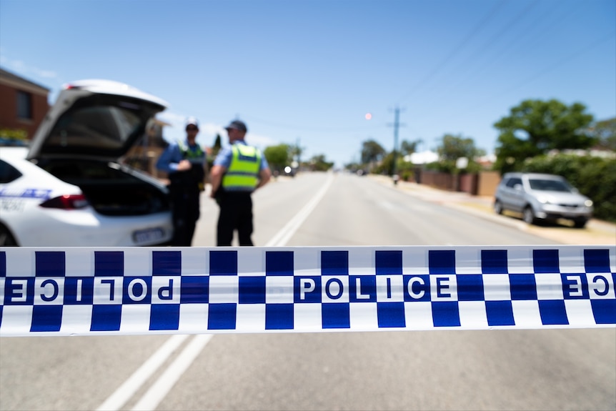 A close-up of police tape across a street.