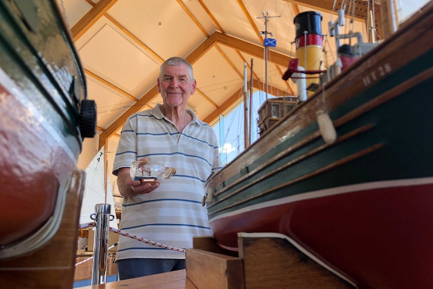 Gary Roberts holds a ship-in-the-bottle from his collection.