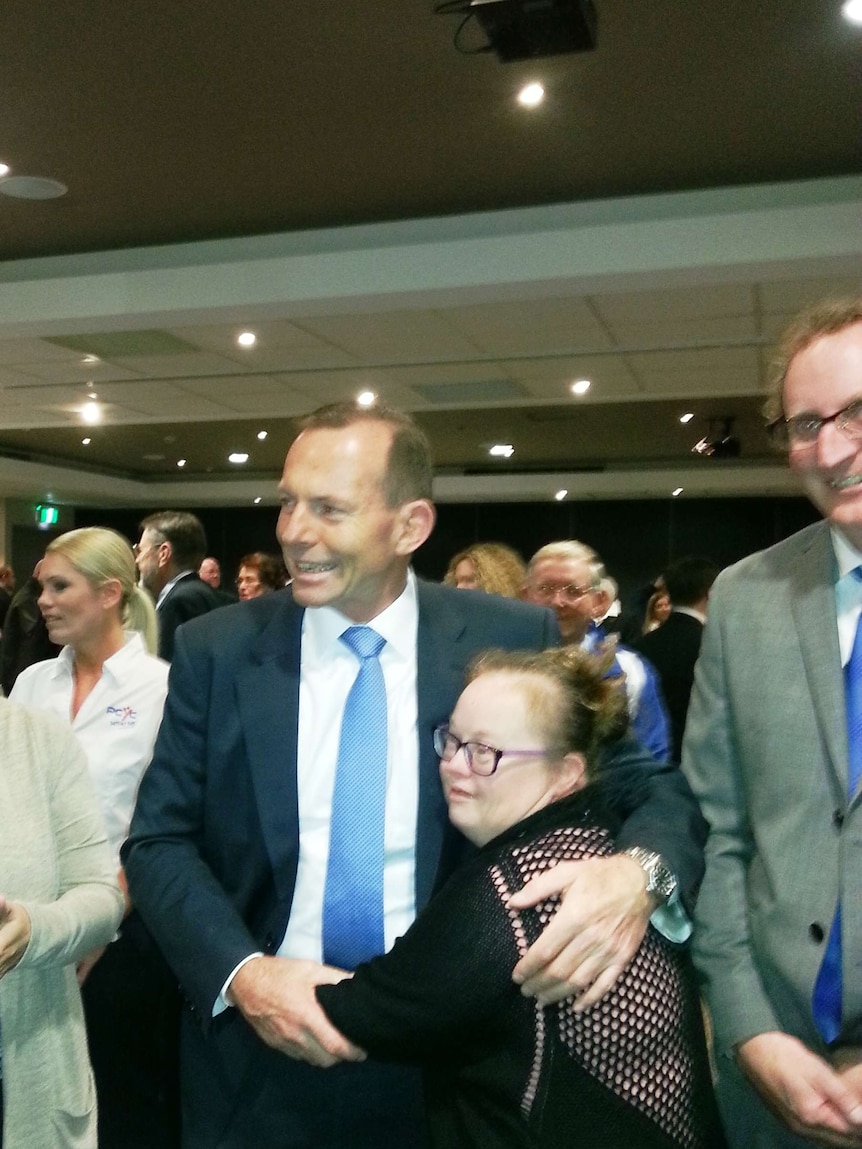Prime Minister Tony Abbott enjoys an embrace from Vivien Vandercroft at Mingara