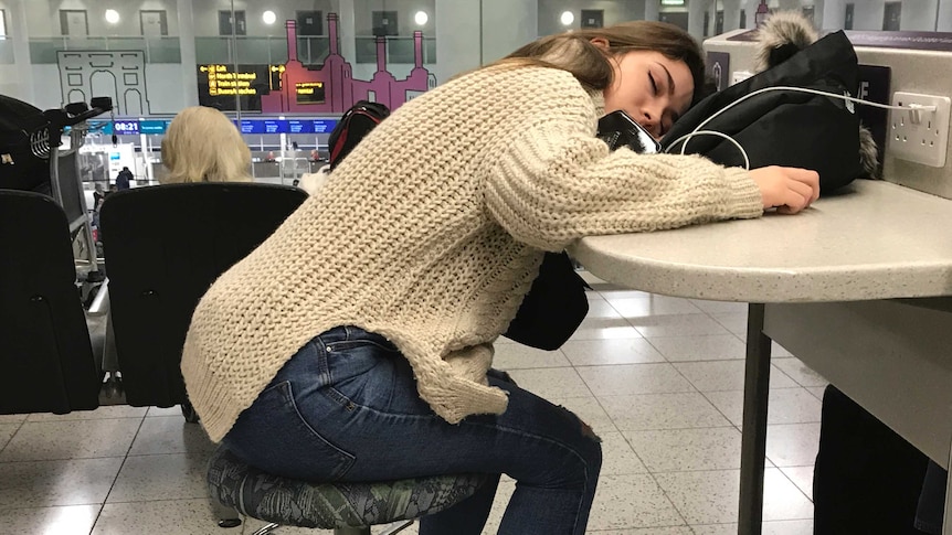 Woman sleeps on table at Gatwick Airport