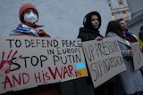 Activists hold banners in Kyiv, one reading 'to defend peace in Europe stop Putin and his war in Ukraine'