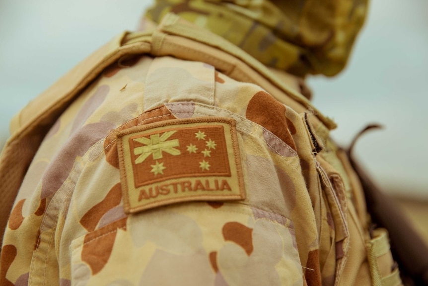 The Australian flag sowed onto the arm of a military uniform worn by a man