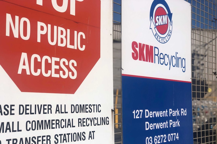 Signs on a gate at a recycling centre