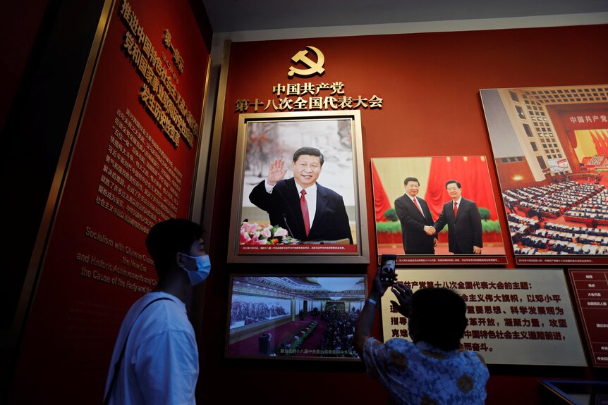 A visitor takes pictures in front of an image of Chinese President Xi Jinping