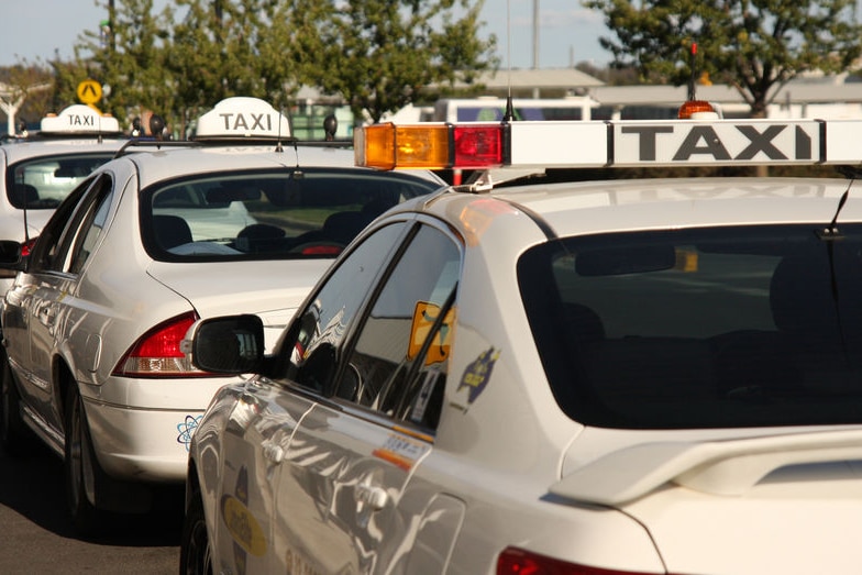 Three taxis wait at a taxi rank