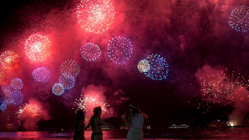 People watch as fireworks explode over Copacabana beach.