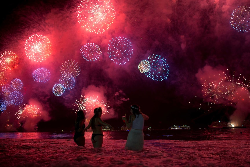 People watch as fireworks explode over Copacabana beach.