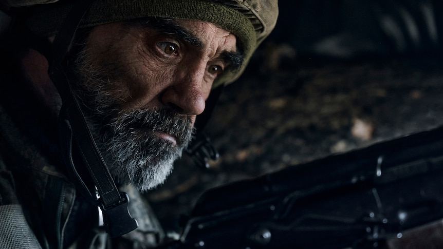 A Ukrainian soldier of the 28th brigade looks down with anxiety on the frontline during a battle with Russian troops.