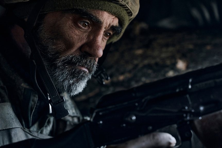 A Ukrainian soldier of the 28th brigade looks down with anxiety on the frontline during a battle with Russian troops.