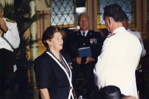 A women dressed formally wearing a Medal of the Order of Australia next to the Governor of New South Wales in 1994