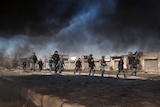 Afghan policemen march towards protesters during a protest near a US military base in Kabul.