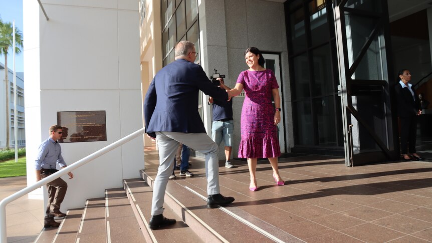Anthony Albanese walks up a set to stairs and shakes hands with Natasha Fyles. 