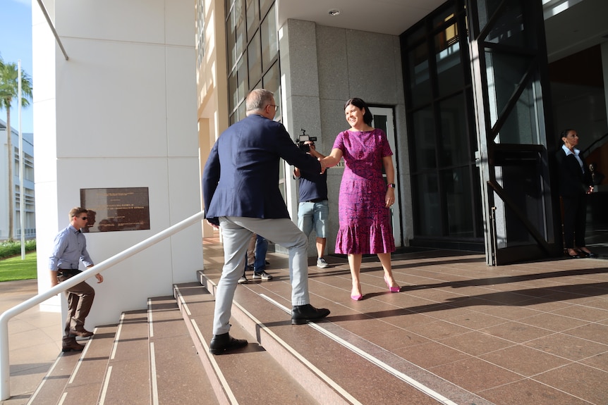 Anthony Albanese walks up a set to stairs and shakes hands with Natasha Fyles. 