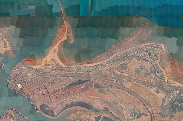 An aerial satellite photograph of a shoreline with a small part marked in red.