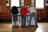 Three men vote at a polling station