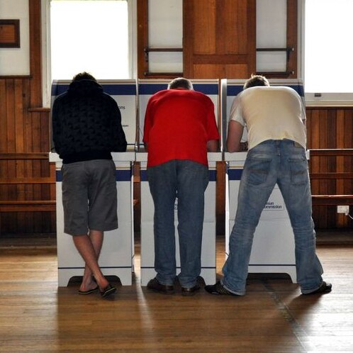 Three men vote at a polling station in Hobart, Tasmania.