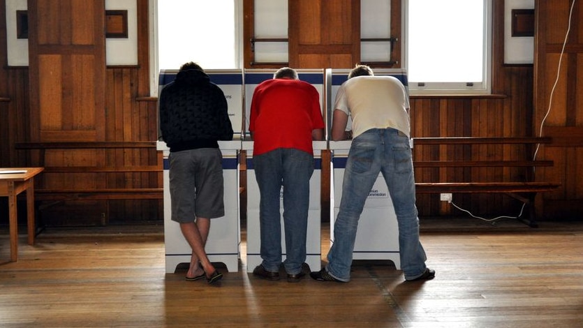 Three men vote at a polling station in Hobart, Tasmania. (ABC: Brigid Andersen)