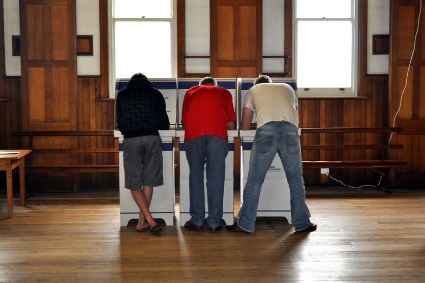 Three men vote at a polling station in Hobart, Tasmania. (ABC: Brigid Andersen)