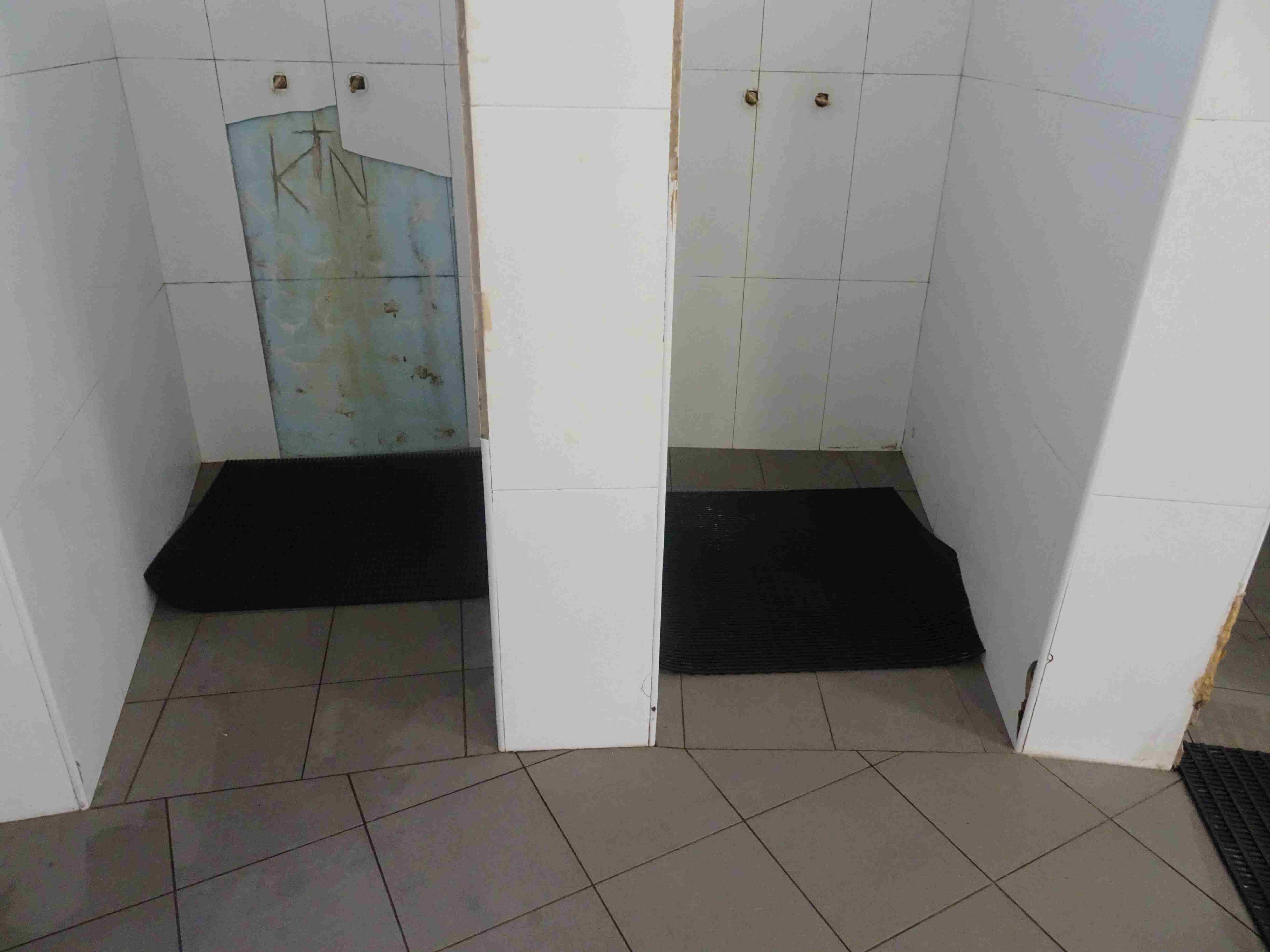 Fotos de azulejos de ducha agrietados en un baño deteriorado en la prisión de Long Bay en Sydney.