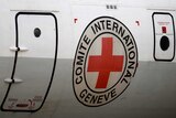 An airplane with the International Committee of the Red Cross emblem near its door