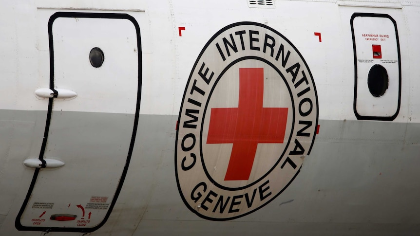 An airplane with the International Committee of the Red Cross emblem near its door