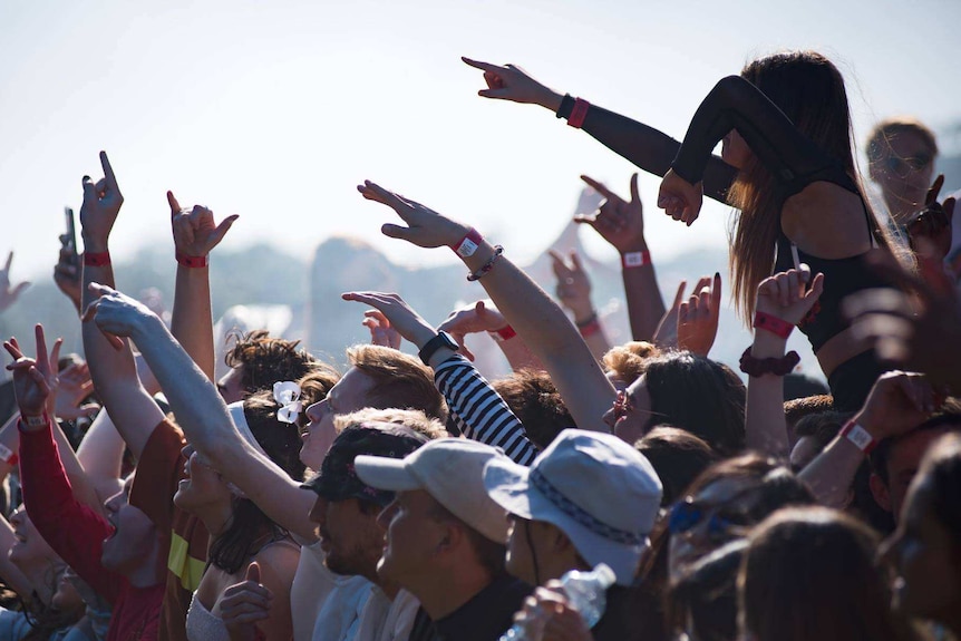 People put their hands in the air at a music festival.
