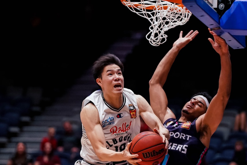 Yudai Baba jumps with the basketball, in front of another player