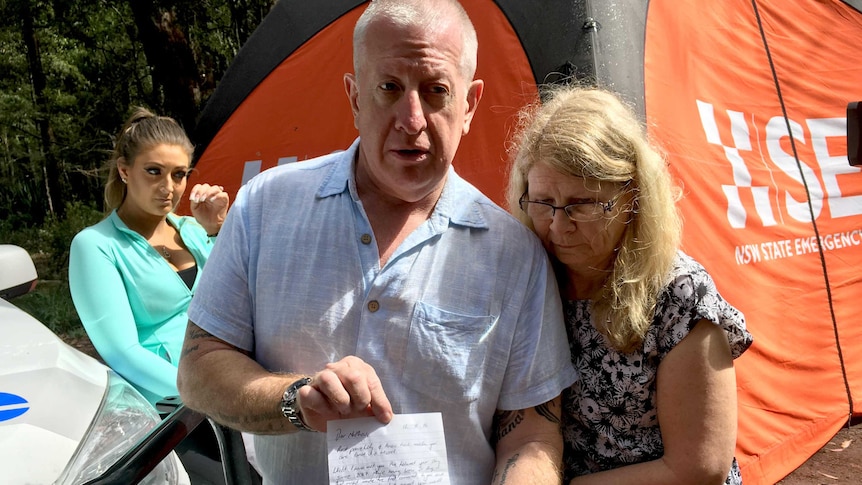 Matthew's parents, Mike and Faye, with a letter tribute left at the body search site.