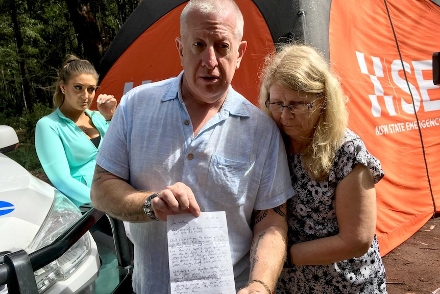 Matthew's parents, Mark and Faye, with a letter tribute left at the body search site.