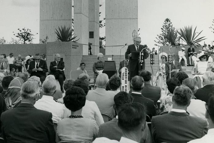 Black and white photo of official opening ceremony of Point Danger lighthouse with dignitaries seated as Mayor speaks