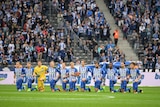 Hertha Berlin players kneel during the German national anthem.