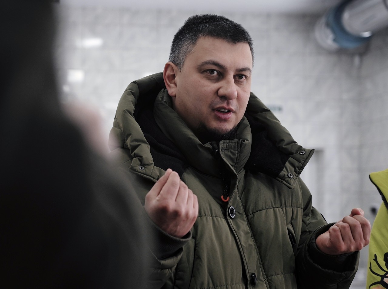 A man speaking, and looking on.