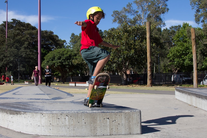 A boy practises in skateboarding skills in Redfern Park