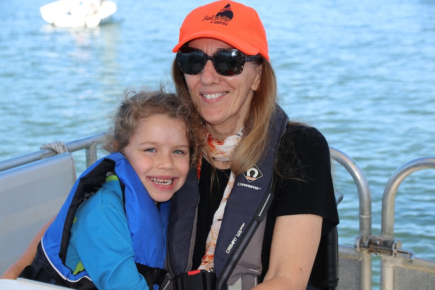 Lady in orange hat with child cuddled up to her