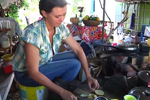 Woman prepares food in kitchen shack