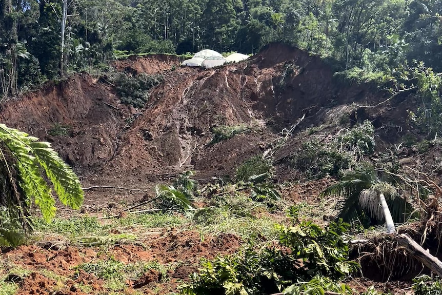 A big section on land has slipped down a hillside, leaving destruction.