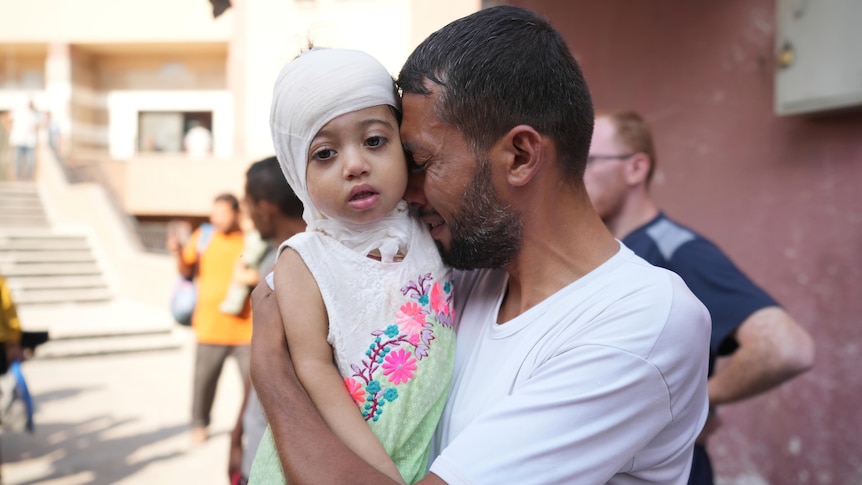 A Palestinian man reacts as he says goodbye to his sick daughter 