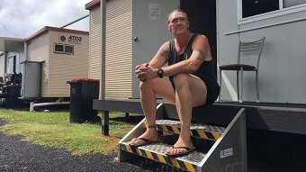 Man sitting on step outside a donga